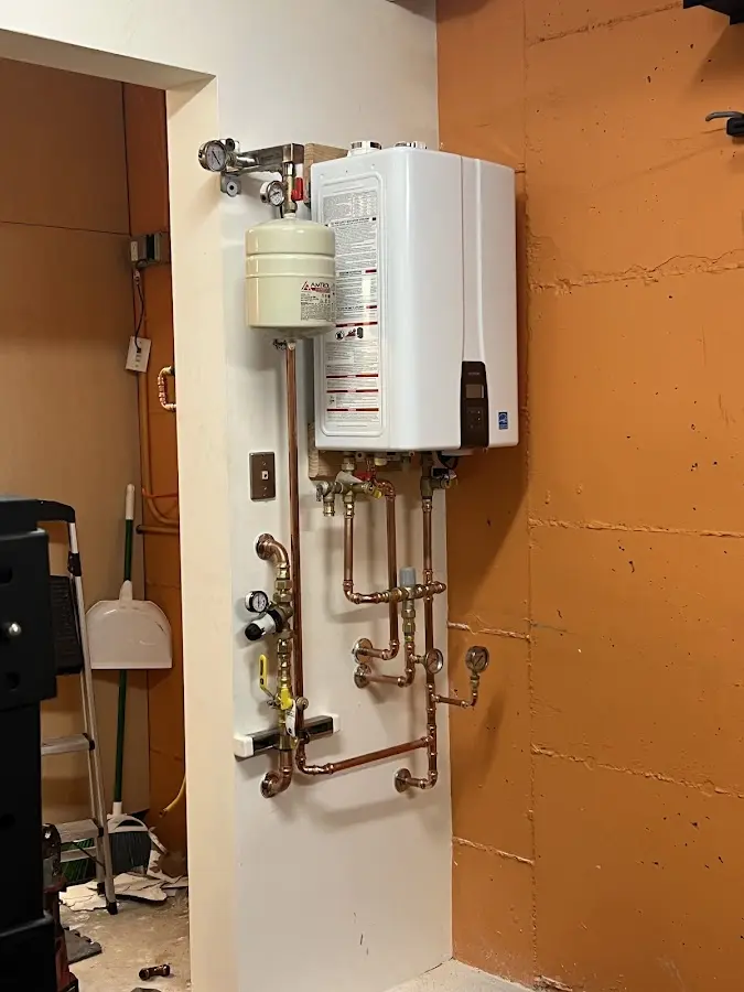 Plumbing technician inspecting water heater connections in Ottawa